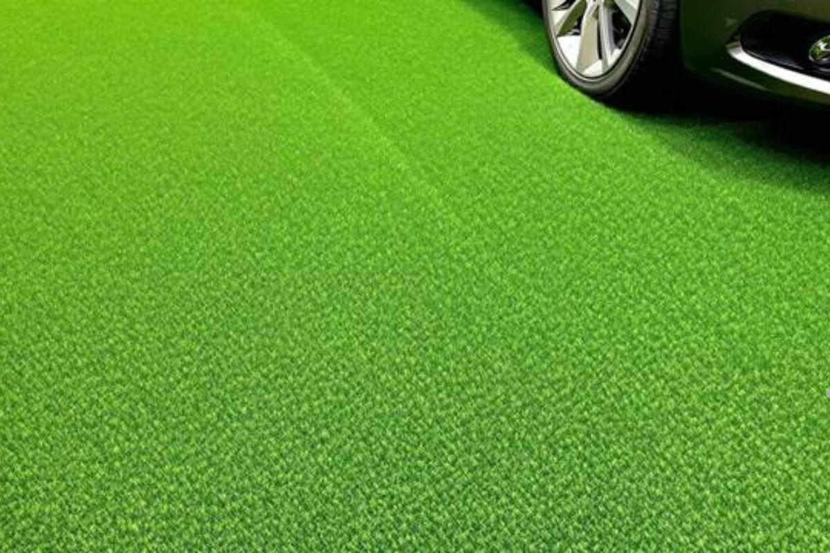 A car parked on a lush green carpet, showcasing a well-maintained lawn service area.